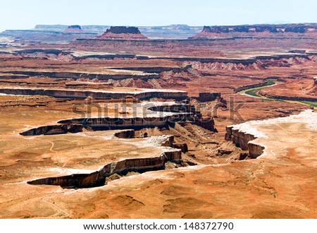 The jagged canyon cut through a desert landscape by Utah's Green River is viewed from high atop the Island in the Sky District of Canyonlands National Park. Royalty-Free Stock Photo #148372790