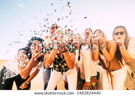 Happiness and joyful concept - group of happy women people celebrate. all together blowing confetti and having fun - new year eve and party event for group of beautiful girls -white clear  background