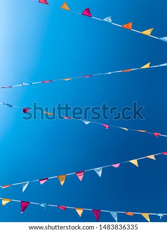 multi-colored carnival flags on a blue sky background