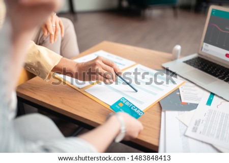 Contract signature. Hands of two Caucasian female business partners sitting at the table while signing a contract in the office