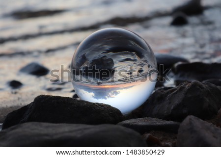 Glass ball photography on the coastal waters creating upside down images of the ocean in the global image beach life