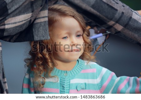 child in a raincoat autumn / autumn view a small child in a raincoat, a park in the city