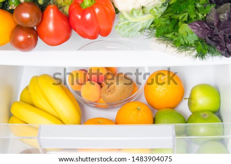 in a white refrigerator, food stock, fresh vegetables on the top shelf, and fruits on the bottom shelf