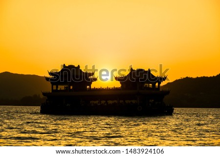 The beautiful of silhouette sunset landscape scenery of Xihu West Lake, Sightseeing boat and pavilion in Hangzhou CHINA.