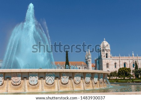 large fountain against the background of the Gothic buildings of the monastery and the blue sky