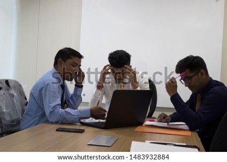 Three businessman unsatisfied after receiving bad news on laptop at office meeting Royalty-Free Stock Photo #1483932884