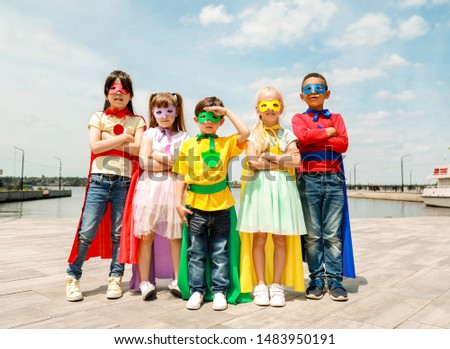 Cute little children dressed as superheroes outdoors