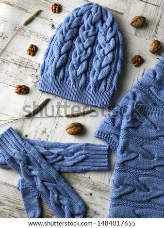blue hand-knitted set: hat, mittens, scarf with orange, dry and wild rose berries, almonds, herbs.