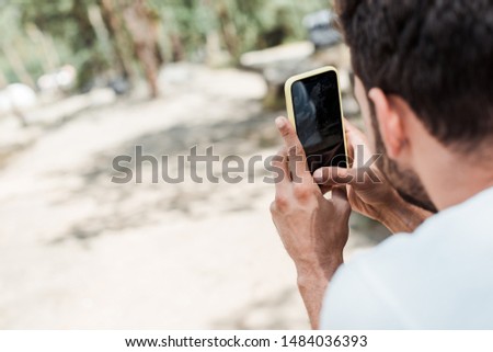 selective focus of man using smartphone with blank screen 