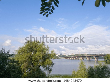 Wide river Dnieper with a bridge after sunrise with beautiful clouds