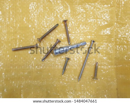 Close-up of screws on yellow background