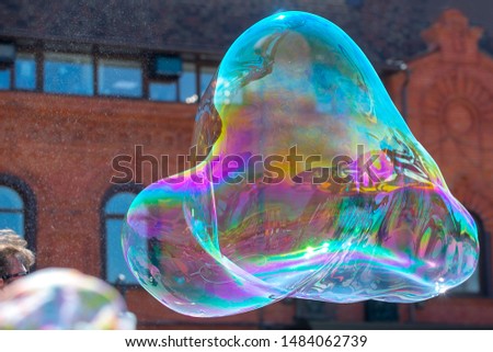 Giant soap bubble on a red brick wall background.