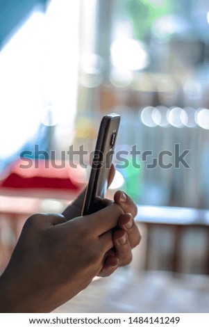 Close-up image of hands using smartphone at home, searching or social networks concept. Hands holding and using modern smart phone with blank screen,taking selfie. Hands with mobile, bright background