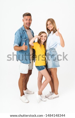 Full length photo of beautiful caucasian family woman and man with little girl smiling and showing thumbs up isolated over white background
