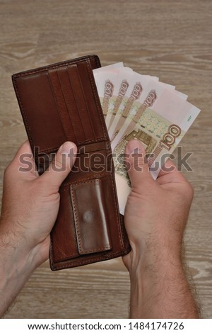 A man's hand takes Russian banknotes from his wallet. Close Up