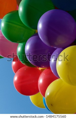 Multi-coloured party balloons pictured against a blue sky. Multi-coloured party balloons pictured against a blue sky.  Blue, Red, Green, Orange, Purple Yellow balloons