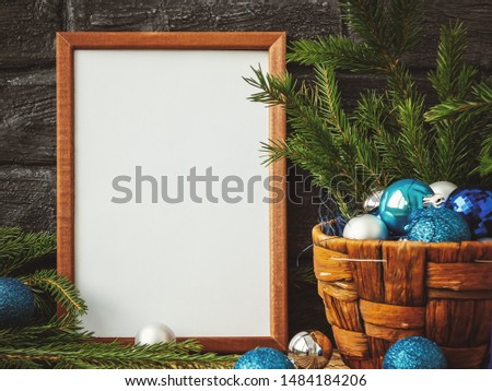 Christmas composition - a wooden frame for text and a basket with fir branches and decorations