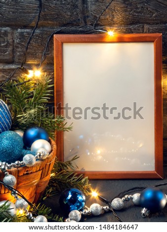Christmas composition with a wooden frame, lights and decorations in a basket, copy space, place for text