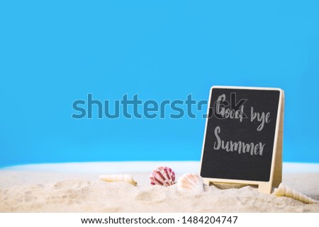 Goodbye Summer text blackboard on the beach with blue sea and clear sky image for outdoor advertising poster summer beach vacation concept.