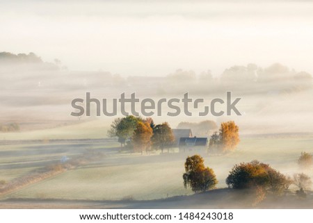 Farm on a field with autumn fog Royalty-Free Stock Photo #1484243018