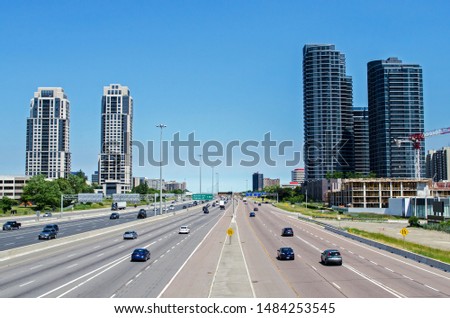 A busy highway surrounded by tall condominiums.