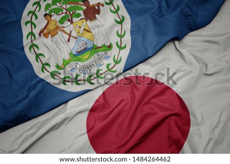 waving colorful flag of japan and national flag of belize. macro