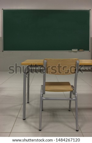 empty class, green blackboard, table and chair