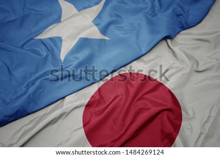 waving colorful flag of japan and national flag of somalia. macro