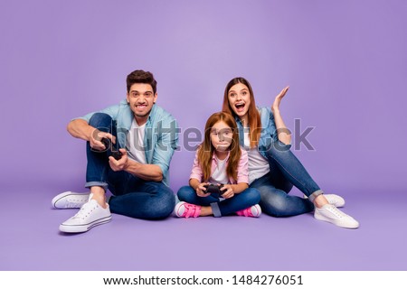 Photo of three family members sitting floor trying hard to win team game wear casual clothes isolated purple background