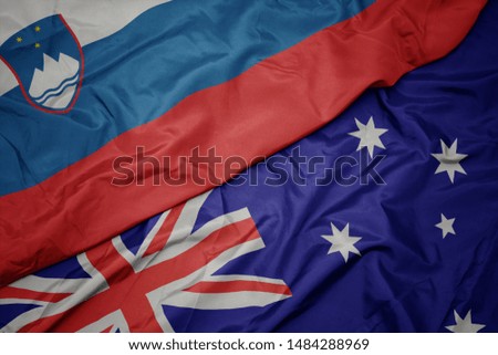 waving colorful flag of australia and national flag of slovenia. macro