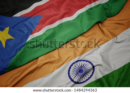 waving colorful flag of india and national flag of south sudan. macro
