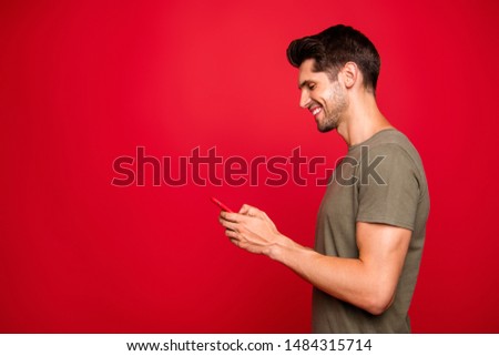 Profile photo of amazing guy holding modern telephone hands casual outfit isolated on bright red background