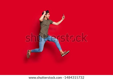 Full size profile photo of cool guy jumping high making selfies wear casual outfit isolated on red background