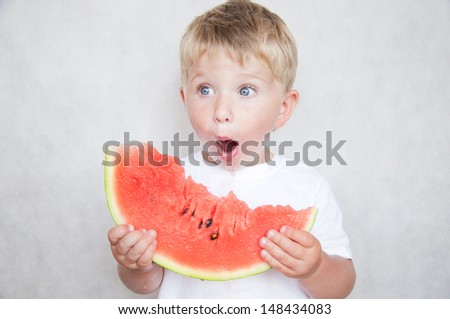 Happy child with big red slice of watermelon on grey background