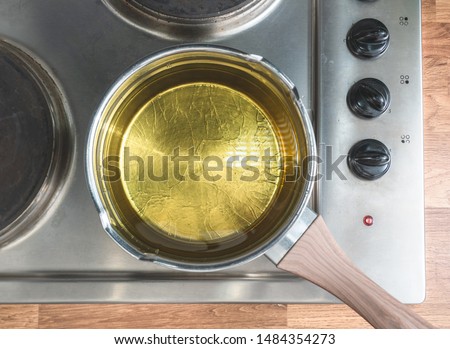 Oil in a pot situated over the stove. View from above Royalty-Free Stock Photo #1484354273