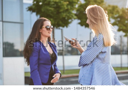 Curious journalist is taking interview from successful businesswoman on the street.