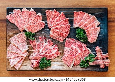 Top view of Premium Rare Slices many parts of Wagyu A5 beef with high-marbled texture on stone plate served for Yakiniku (Grilled Meat). Royalty-Free Stock Photo #1484359859