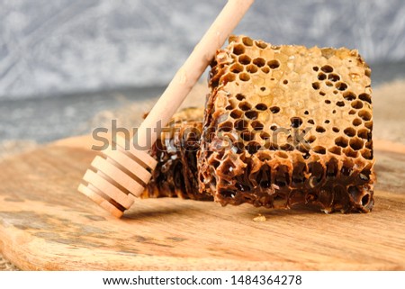 honeycomb with honey on a wooden Board, and a spoon for honey, selective focus