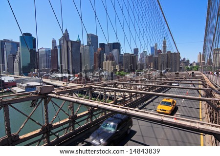 Yellow taxi on Brooklyn bridge with Manhattan skyline in the background - New York City, USA