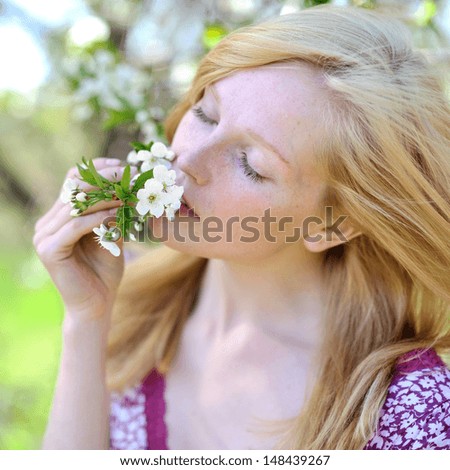 Young girl in blooming tree in spring 