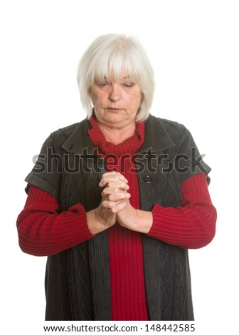 Portraits of a senior Caucasian woman in casual clothing, hands folder for a prayer. Isolated on white background.