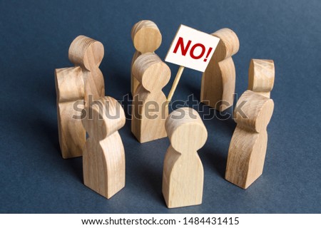 Person holding a NO poster surrounded by people. The concept of bullying and protest against. Disagreement and conviction for dissent. Strike Agitation and cooperation. Resistance and civil society. Royalty-Free Stock Photo #1484431415