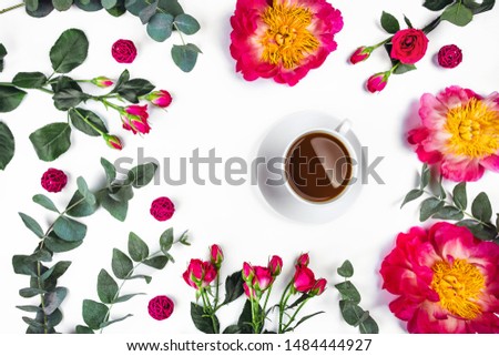 Isolated white background with a Cup of coffee surrounded by flowers. Flat lay, top view.