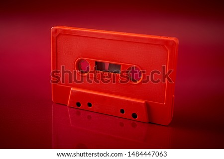 old orange audio cassette on the dark red background