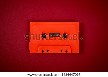 old orange audio cassette on the dark red background