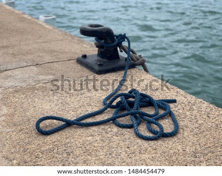Maritime rope and mooring anchorage at the seaport on stony pier