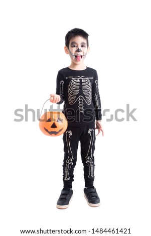 Little asian boy in skeleton costume for halloween celebration holding pumpkin bucket standing over white background