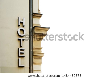 hotel sign on the wall background. empty copy space for inscription. Vintage sign.  vertical hotel sign mounted on beige facade of hotel. Hotel in Krakow, Poland