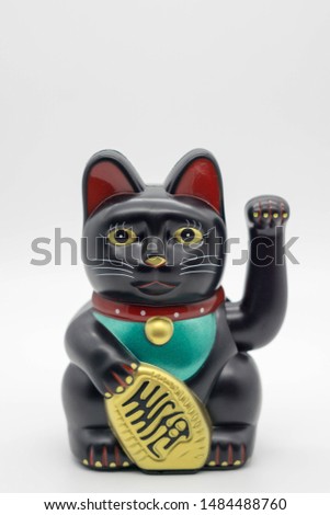 close up of a black lucky cat isolated white background
