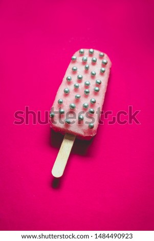 Pink ice cream with silver pearls on a pink background